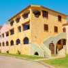 Edificio colorato a più piani con balconi e archi.
