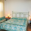 Camera da letto con letto in ferro battuto e arredi azzurri.