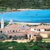 Complesso di case vicino a una baia con sabbia bianca.