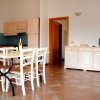 Sala da pranzo con tavolo e sedie bianche.