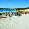 Spiaggia con ombrelloni gialli e lettini.