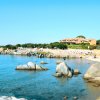 Spiaggia con scogli e edifici sullo sfondo.