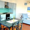 Cucina con tavolo, sedie e divano blu.