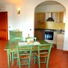 Cucina color legno con tavolo verde e sedie.