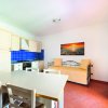 Cucina bianca con piastrelle blu e divano beige.