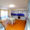 Cucina azzurra con piastrelle blu, tavolo bianco.