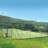Campo da tennis in mezzo al verde.