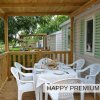 Veranda con tavolo apparecchiato e sedie bianche.