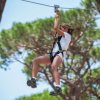 Persona in zipline tra alberi.