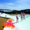 Bambini che giocano in una piscina con uno scivolo.