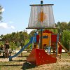 Area giochi a forma di nave con scivolo in un parco.