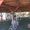 Una palestra all'aperto con attrezzi sotto una tettoia di legno.