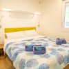 Una camera da letto con letto matrimoniale, coperta colorata e asciugamani piegati.