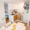 Un'area soggiorno e cucina di una casa mobile con tavolo da pranzo, frigorifero, lavabo e fornelli.