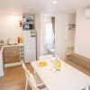 Cucina moderna con tavolo bianco e quattro sedie.