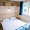 Camera da letto con letto matrimoniale, mensole, e finestra con tenda blu.