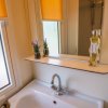 Lavandino del bagno con specchio, piante in vaso e flacone di sapone.
