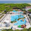 Vista aerea di un parco acquatico con piscine e scivoli, vicino al mare.