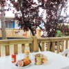 Tavolo bianco all'aperto con pane, bibite e alberi sullo sfondo.