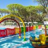 Area giochi acquatica con archi colorati e un piccolo scivolo a forma di barca.