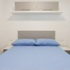 Camera da letto con letto matrimoniale e mensola sopra.