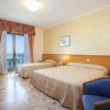 Due letti in una camera d'hotel con vista mare e arredi classici.