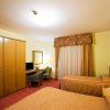Camera d'albergo con due letti singoli, armadio, scrivania e sedia.