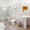 Bagno moderno con lavandino, bidet, doccia in vetro e specchio illuminato.