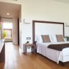Camera da letto moderna con letto matrimoniale e fiori su un tavolo.