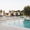 Piscina con ombrelloni e sdraio bianche.