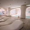 Spa interna con lettini curvi e piscina.