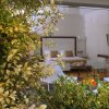 Camera con giardino e sedie bianche.