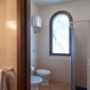 Bagno con doccia, finestra curva e asciugamani.