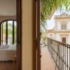 Vista sul balcone con palme e edificio.