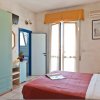 Camera da letto con letto matrimoniale, armadio verde, scrivania e accesso a un balcone.