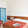 Camera da letto con letto matrimoniale, copriletto rosso e porta blu.