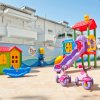 Parco giochi colorato con scivolo e casetta.