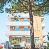 Edificio a più piani con balconi e albero.