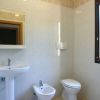 Bagno con lavabo, bidet e wc vicino a una finestra.