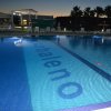 Piscina illuminata di sera con scritta 