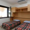 Camera da letto con due letti singoli e plaid a quadri.