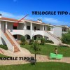 Complesso residenziale con scale esterne e prato.