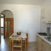 Cucina essenziale con tavolo e sedie.