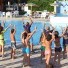 Gruppo di persone che fa attività in una piscina all'aperto.