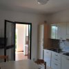 Cucina con tavolo, sedie e porta aperta.