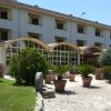 Edificio a tre piani con giardino e vasi di piante.