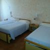 Camera d'hotel con due letti e comodini.