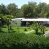Edificio bianco circondato da alberi e giardino curato.