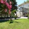 Giardino con fiori, panchine e edificio bianco.