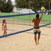 Persone giocano a beach volley su sabbia.